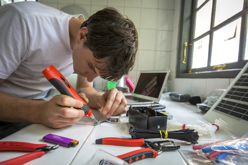 White assembles a cell phone listening device. Source: Rainforest Connection